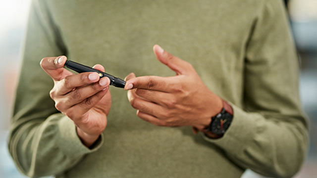 Man uses a glucometer on his finger
