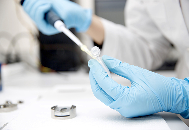 Close-up of researcher using a pipette.